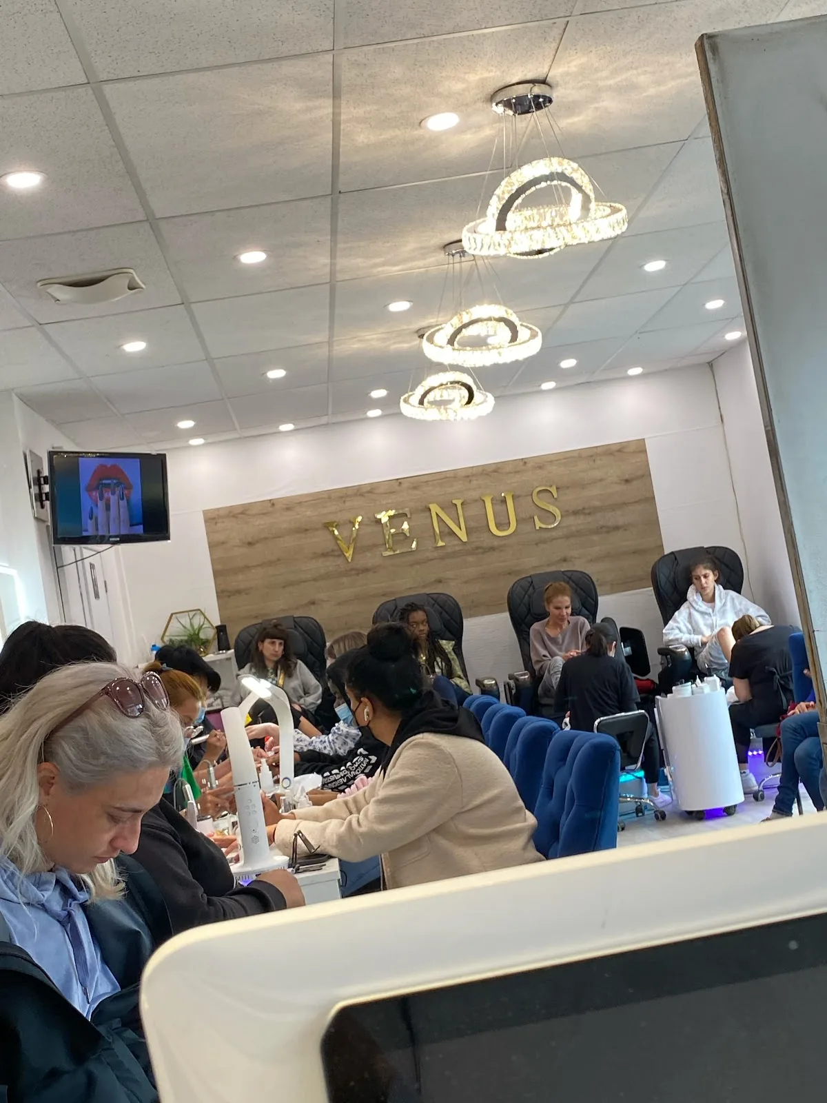 Clients enjoying manicure services inside Ongles Venus.